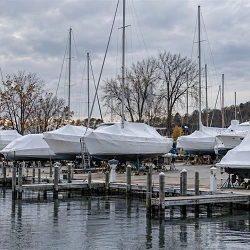 Shrink-wrapped sailboats and powerboats on stands in a Lake Michigan marina for winter storage