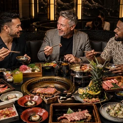 Three friends sharing hot pot, Korean BBQ and sushi during a Las Vegas guys trip in an upscale Asian restaurant