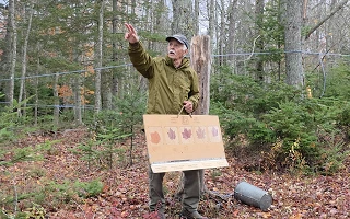 Gig Keirstead holding a board of maple leaf species in the maple woods at Elmhurst Outdoors near Saint John, New Brunswick